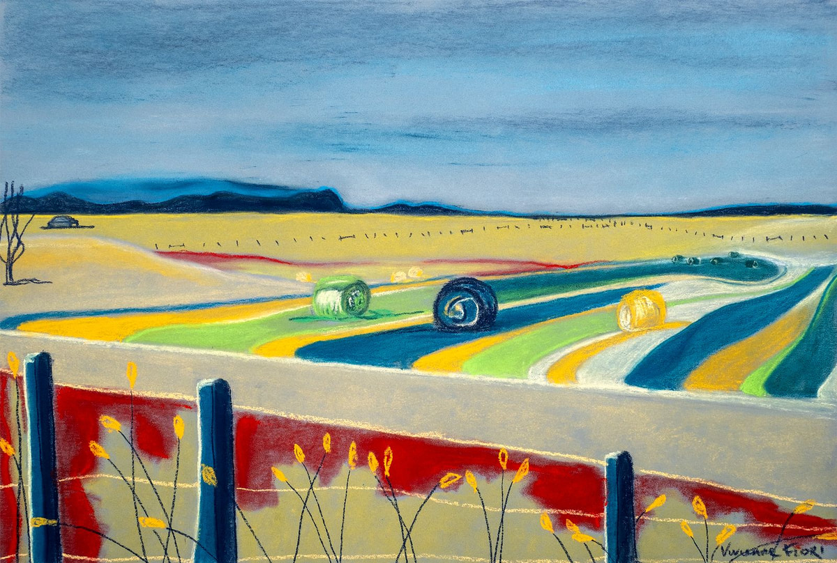 Colour Haybales. A broad landscape of yellow fields, blue water and repeated haybale forms.
